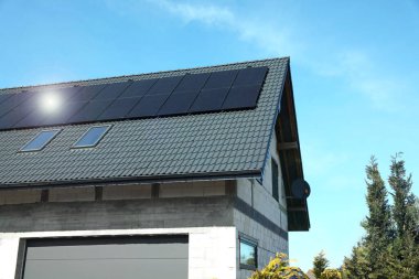 Çatıda güneş panelleri olan bir ev. Alternatif enerji