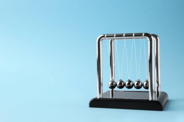 Newton 'un açık mavi arka plandaki beşiği, metin için boşluk. Enerji korunumunun fizik yasası