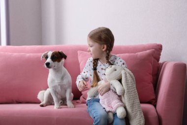 Köpeği ve oyuncak tavşancığıyla küçük şirin bir kız. Çocukluk hayvanı.