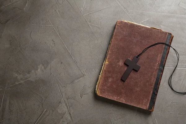 Wooden Christian Cross Old Bible Grey Table Top View Space — Zdjęcie stockowe