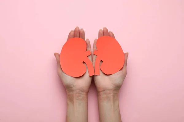 Woman Holding Paper Cutout Kidneys Pink Background Top View — Stock Photo, Image