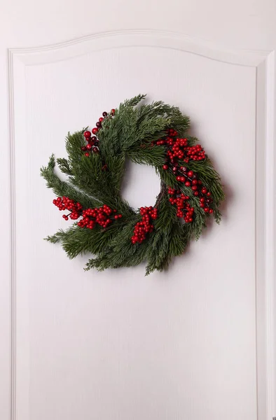 Όμορφο Χριστουγεννιάτικο Στεφάνι Κόκκινα Μούρα Κρεμασμένα Στη Λευκή Πόρτα — Φωτογραφία Αρχείου