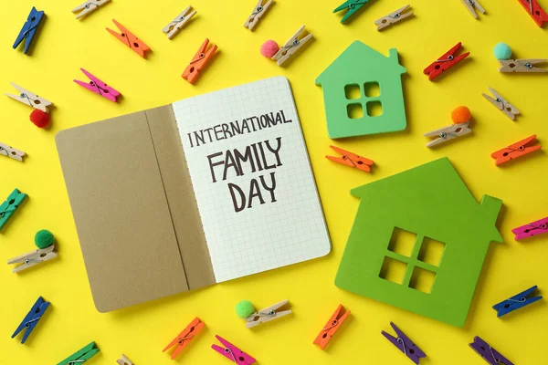 国际家庭日快乐 带黄色背景的笔记本电脑和房屋模型的平面布局构图 — 图库照片