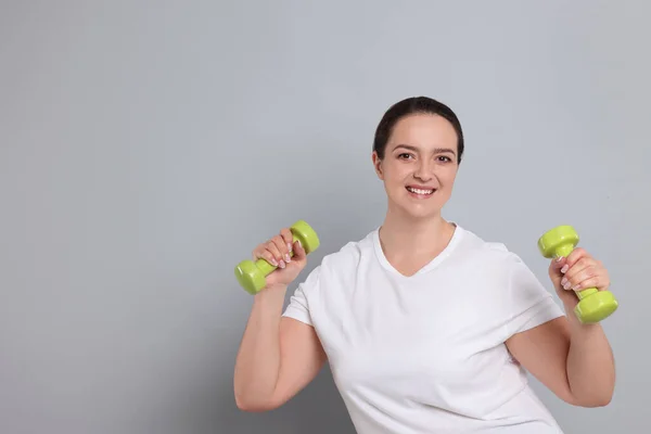 Happy Overweight Woman Doing Exercise Dumbbells Grey Background Space Text — ストック写真