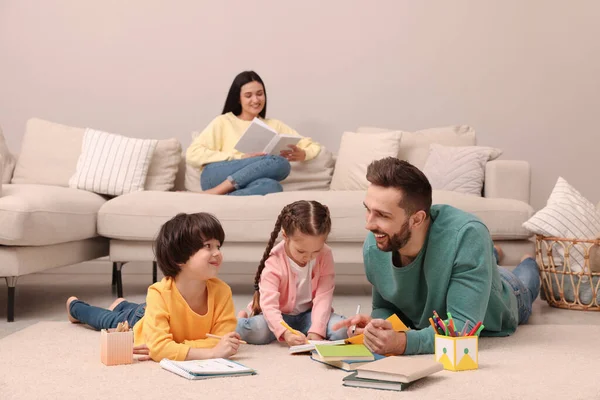 Vader Speelt Met Zijn Kinderen Terwijl Moeder Boek Leest Bank — Stockfoto