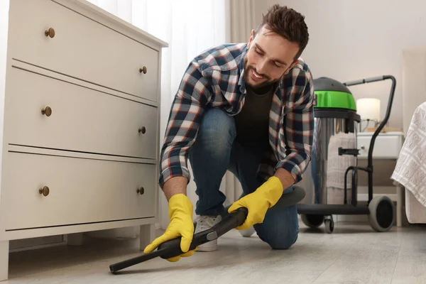 Man Vacuuming Floor Chest Drawers Indoors — Stock Photo, Image