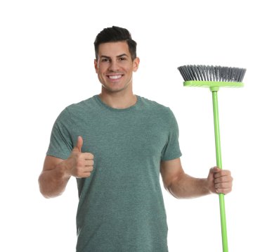 Beyaz arka planda yeşil süpürgesi olan adam.