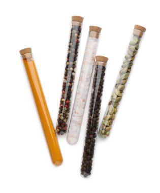 Beyaz arka planda farklı baharatlı cam tüpler, üst görünüm