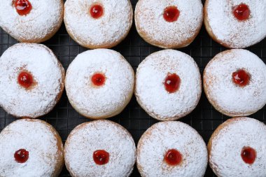 Soğutma rafında jöle ve pudra şekerli bir sürü lezzetli çörek, üst manzara.