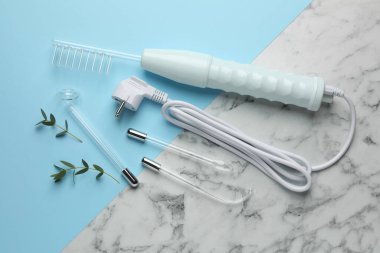 Flat lay composition with darsonval and different nozzles on color background