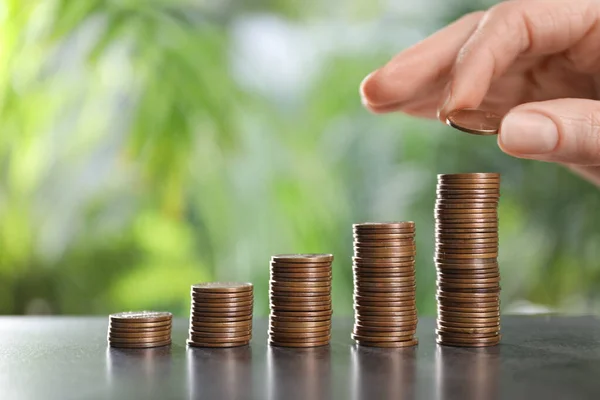 Woman Stacking Coins Grey Table Blurred Green Background Closeup Space — стоковое фото