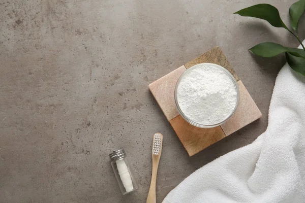 Flat lay composition with tooth powder on grey table, space for text