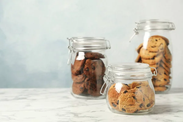 Delicious Chocolate Chip Cookies Glass Jars White Marble Table Space — стоковое фото