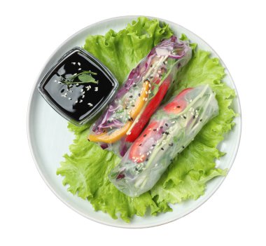 Pirinç kağıdına sarılmış lezzetli rulo ve beyaz arka planda teriyaki soslu tabak.