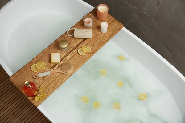 Holzbadewanne Mit Kerzen Und Pflegeprodukten Auf Badewanne Drinnen Oben Blick — Stockfoto