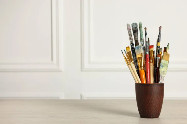 Different Paintbrushes Holder White Wooden Table Space Text — Zdjęcie stockowe