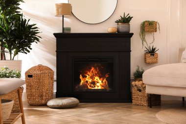 Elektrik şöminesi ve güzel dekor elementleri olan şık bir oda.