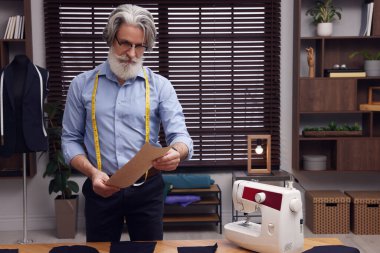 Çalışma masasının yanında robot resmi olan profesyonel bir terzi, metin için yer