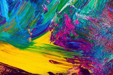 Arkaplan olarak karışık parlak boya içeren ressamın paletinin yakın görüntüsü