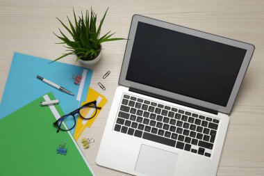 Modern dizüstü bilgisayar, gözlükler ve ofis kağıtları beyaz ahşap masa, düz yatak. Uzaklık öğrenimi