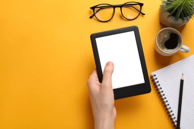 Turuncu arka planda e-kitap okuyan bir kadın. Metin için boşluk