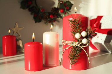 Beyaz masada Noel dekoru ile mum yakmak