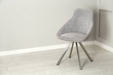 Odadaki ışık duvarının yanındaki şık sandalye. Metin için boşluk