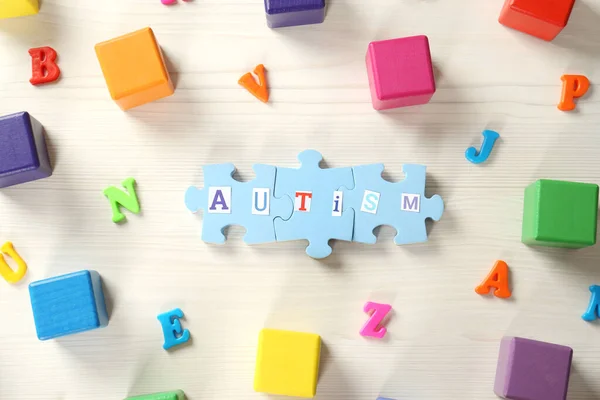 Word Autisme Gemaakt Van Puzzelstukjes Kleurrijke Blokjes Letters Witte Houten — Stockfoto