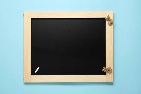 干净的小黑板 白色粉笔 浅蓝色背景 顶视图 — 图库照片