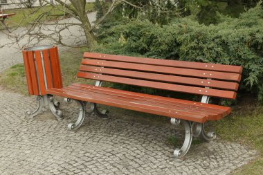 Bahar günü parkta ahşap bank ve çöp kutusu