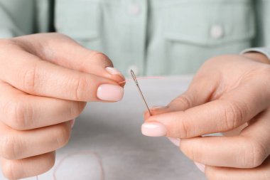 Dikiş iğnesi diken kadın, yakın plan.