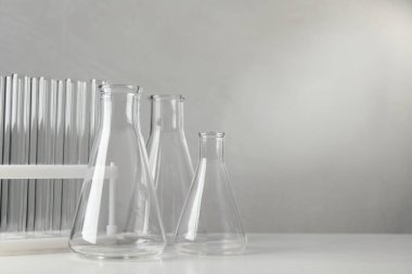 Beyaz tablo üzerinde gri arkaplan, metin için alan karşısındaki laboratuvar camları kümesi