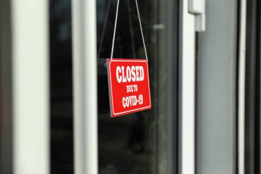 Camda asılı duran Covid-19 nedeniyle kapalı olan kırmızı tabela. Coronavirus karantinası