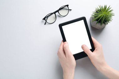 Beyaz arka planda e-kitap okuyan bir kadın. Metin için boşluk