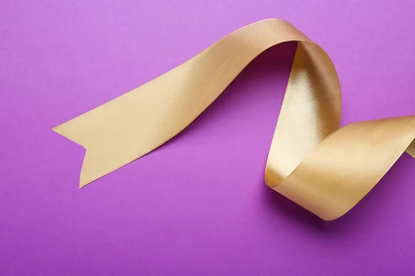 Beautiful Golden Ribbon Purple Background Top View — Zdjęcie stockowe