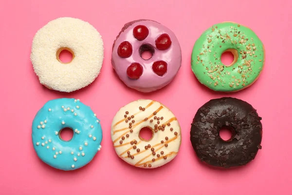 Diferentes Deliciosos Donuts Envidraçados Fundo Rosa Flat Lay — Fotografia de Stock