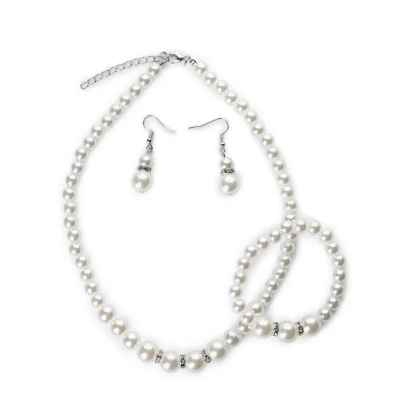 白色背景的精致珍珠项链 手镯和耳环 上视图 — 图库照片