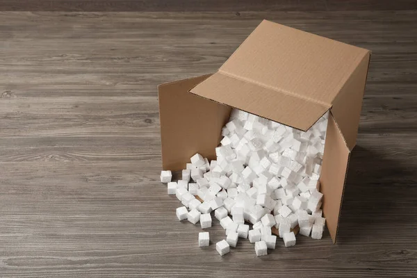 Overturned Cardboard Box Styrofoam Cubes Wooden Floor Space Text — Stok fotoğraf