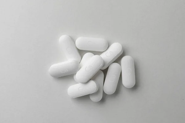Pile Calcium Supplement Pills Light Grey Background Flat Lay — стоковое фото