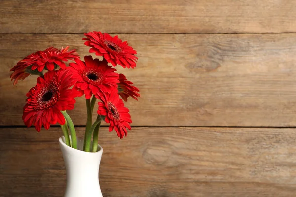 Ahşap Arka Planda Seramik Vazoda Güzel Kırmızı Gerbera Çiçekleri Metin — Stok fotoğraf