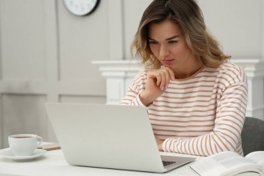 Çevrimiçi test. Evde dizüstü bilgisayarla çalışan bir kadın