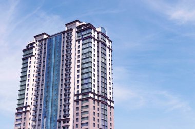 Modern skyscraper against blue sky with clouds. Space for text