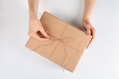 Beyaz arka plan, üst görünüm üzerine Kraft kağıdına sarılı paketleri tutan kadın