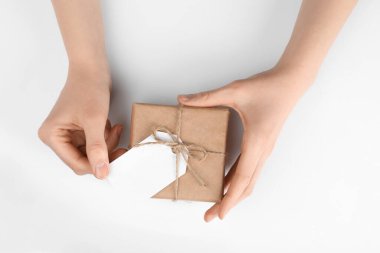 Beyaz arkaplanda etiketli bir pakete sarılı kadın, üst görünüm