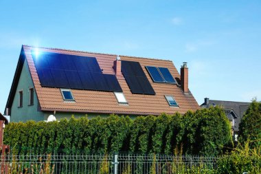 House with installed solar panels on roof. Alternative energy clipart