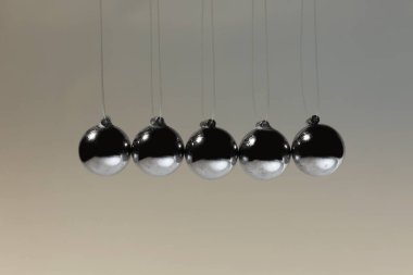 Newton 'un gri arka plandaki beşiği. Enerji korunumunun fizik yasası