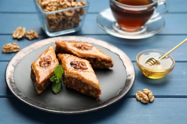 Mavi ahşap masada cevizli ve nane şekerli enfes bir baklava.