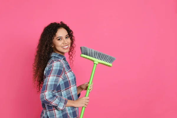 African American Woman Green Broom Pink Background Space Text — стоковое фото