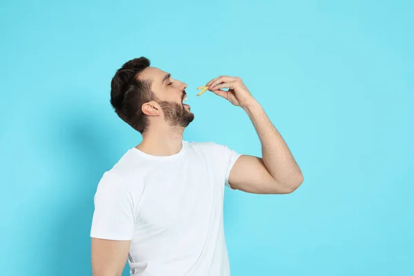 Man Eating French Fries Light Blue Background — ストック写真