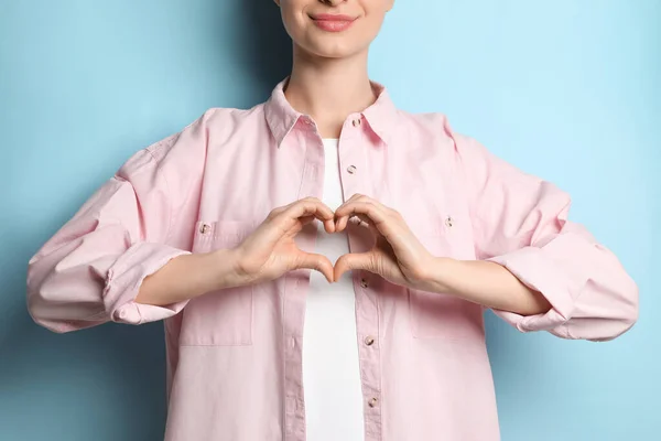 Mujer Haciendo Corazón Con Las Manos Sobre Fondo Azul Claro —  Fotos de Stock